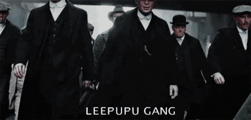a group of men in suits and hats are walking in a line with the words leepupu gang written on the bottom .