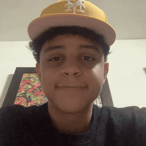 a young man wearing a yellow hat that says nyc on it