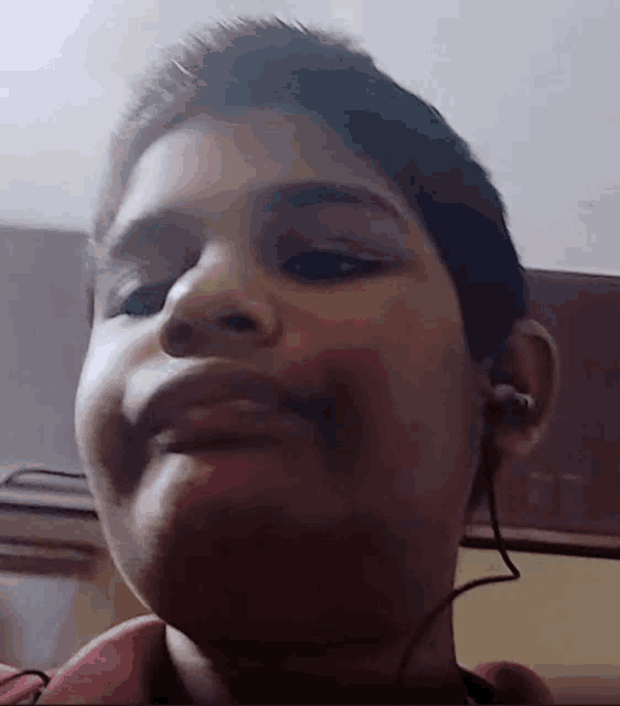 a boy wearing ear buds looks at the camera