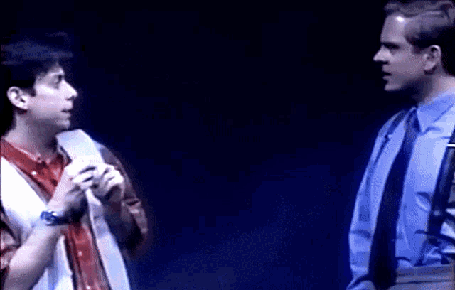 two men standing next to each other on a stage