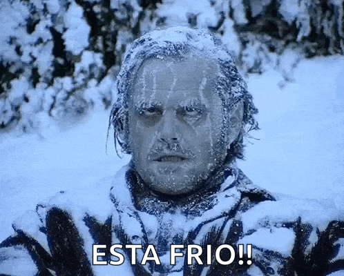 a man covered in snow with the words esta frio written on his face .