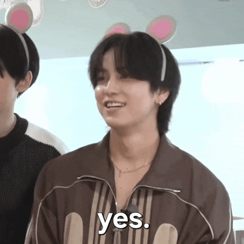 a young man wearing a headband with bunny ears says yes