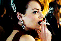 a woman in a red dress is smoking a cigarette with smoke coming out of her mouth