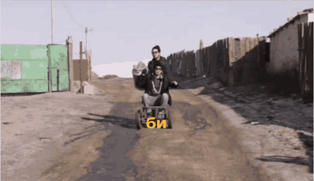 a man in a wheelchair is pushed by another man in a wheelbarrow with the letters bi on the side