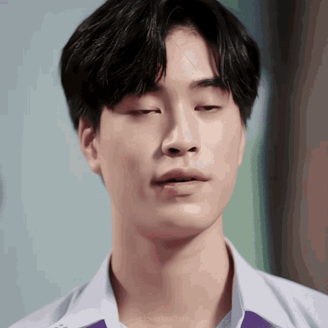 a close up of a young man 's face with the words cloverfearbae visible