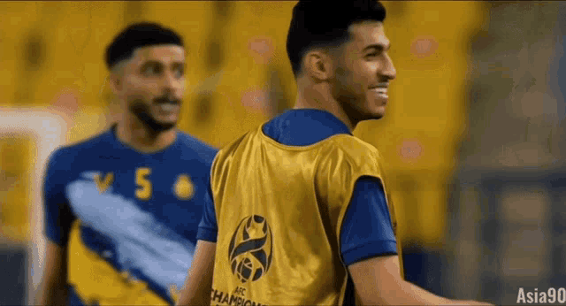 a soccer player wearing a yellow vest that says champions on the back