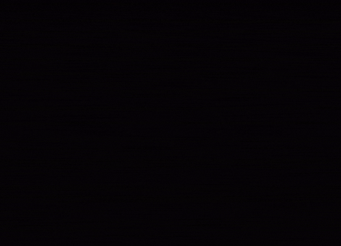a statue of a rabbit in a dark room with a light shining on it