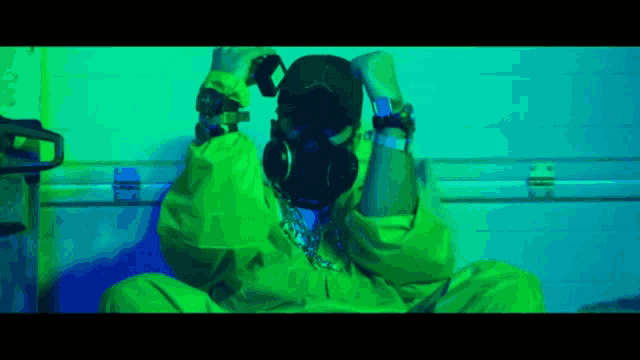 a man wearing a gas mask and a green suit