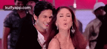 a man and a woman are dancing together in a crowd of people .