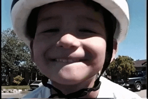 a young boy wearing a helmet smiles at the camera