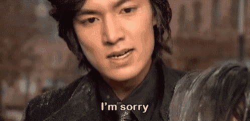 a man in a black jacket and tie is saying `` i 'm sorry '' while holding a woman .
