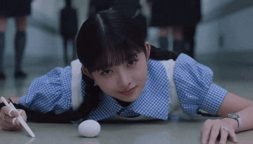 a girl laying on the floor with a white egg