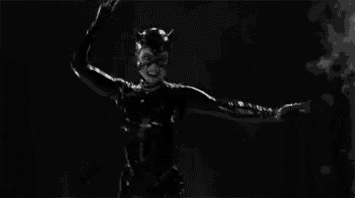 a black and white photo of a woman in a catsuit .