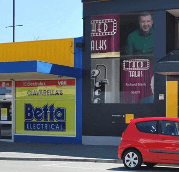 a red car is parked in front of a store called betta