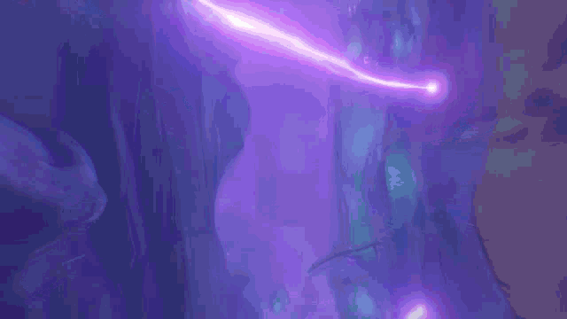 a purple lightning bolt is coming out of the ground in a dark cave .