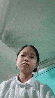 a girl in a white shirt is taking a selfie