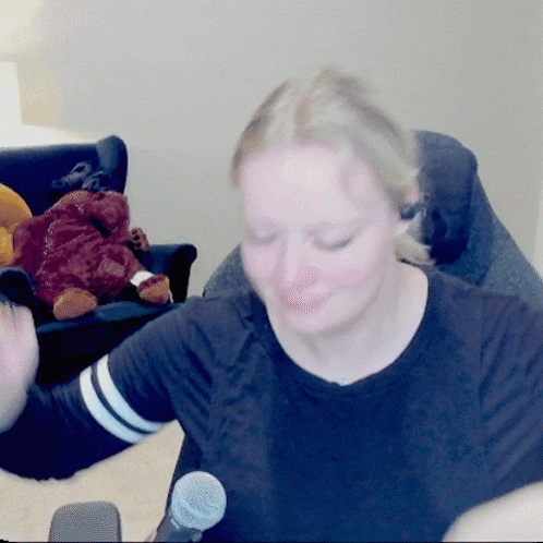 a woman in a black shirt is holding a microphone
