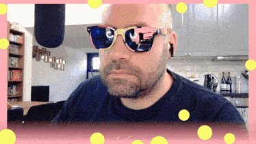 a man with a beard wearing sunglasses with a pink and blue frame