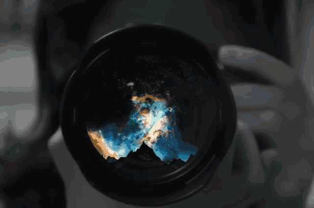 a person is taking a picture of a purple galaxy with a camera lens