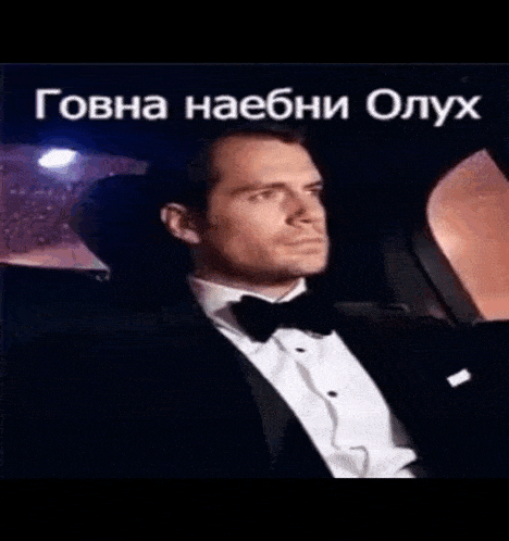 a man in a tuxedo is sitting in the back seat of a car .
