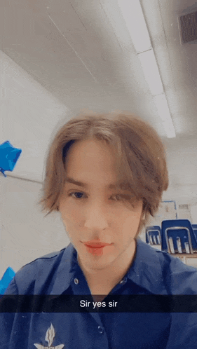 a young man in a blue shirt with the words sir yes sir on the bottom