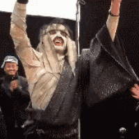 a man in a costume is holding up his arms in the air
