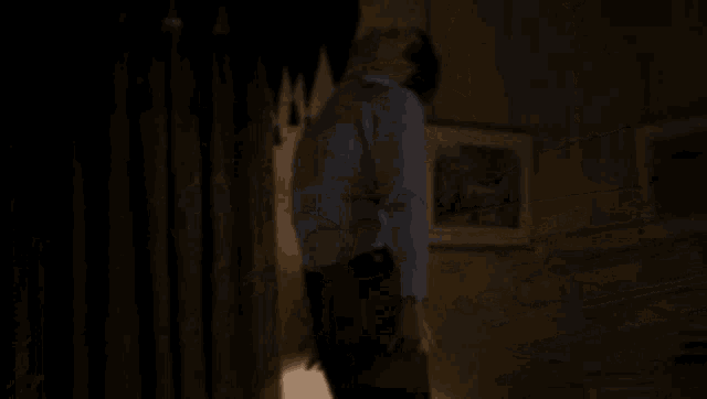 a person is laying on a bed in a dark room with a lamp