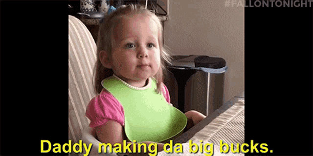 a little girl wearing a bib is sitting in a high chair and says `` daddy making da big bucks '' .