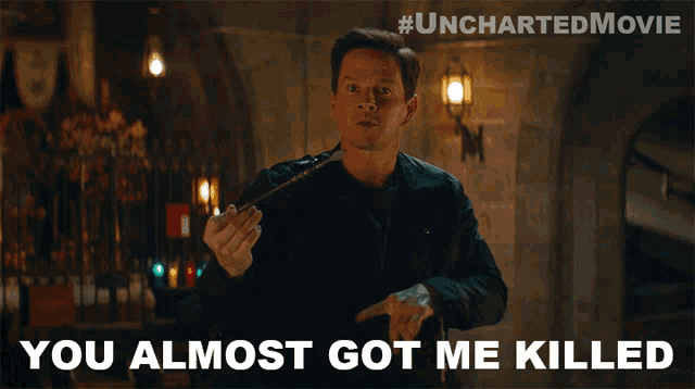 a poster for the uncharted movie shows a man holding a sword