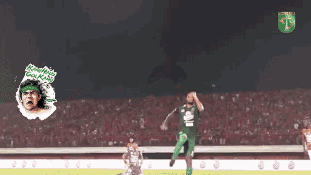 a soccer player in a green jersey is jumping in the air on a soccer field