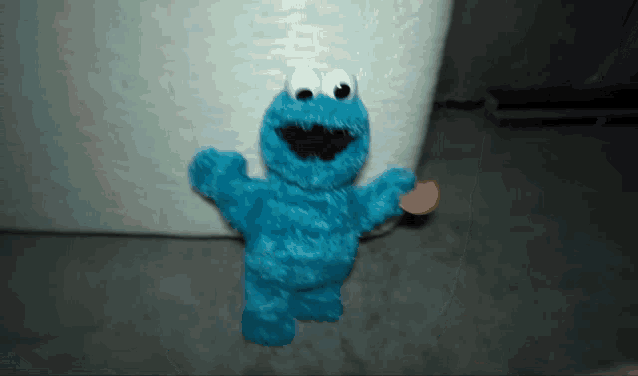 cookie monster from sesame street holding a cookie