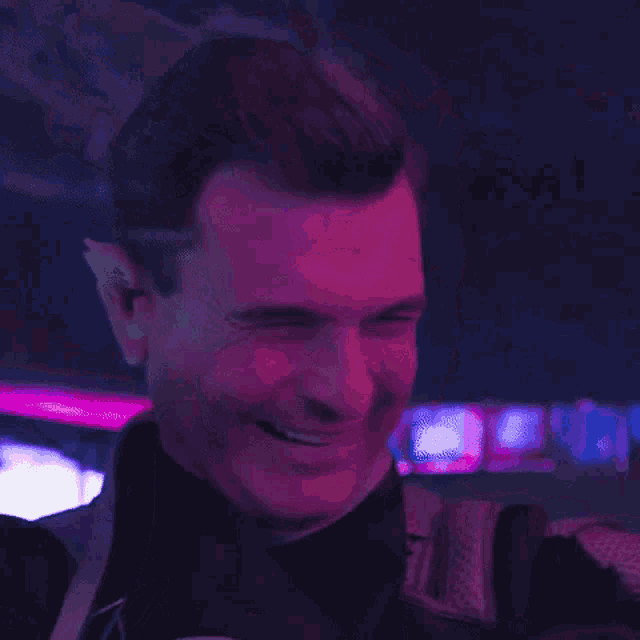 a close up of a man 's face with a pink background