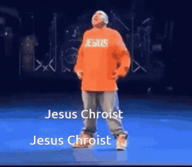 a man wearing an orange shirt that says jesus on it