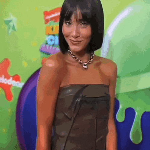 a woman standing in front of a nickelodeon sign