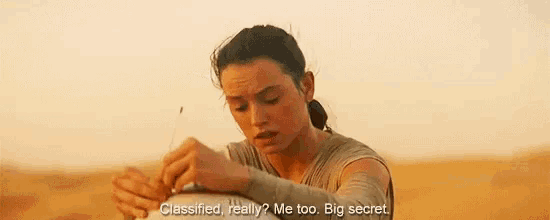 a close up of a person holding a robot with the words `` classified really ? me too big secret '' written on it .