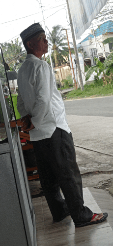 a man wearing a white shirt and black pants is standing in front of a building