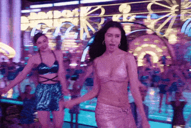two women are dancing in front of a mirror in a club