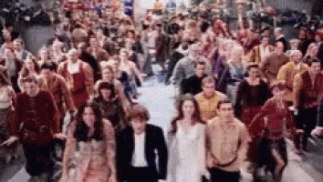 a crowd of people are walking down a street .