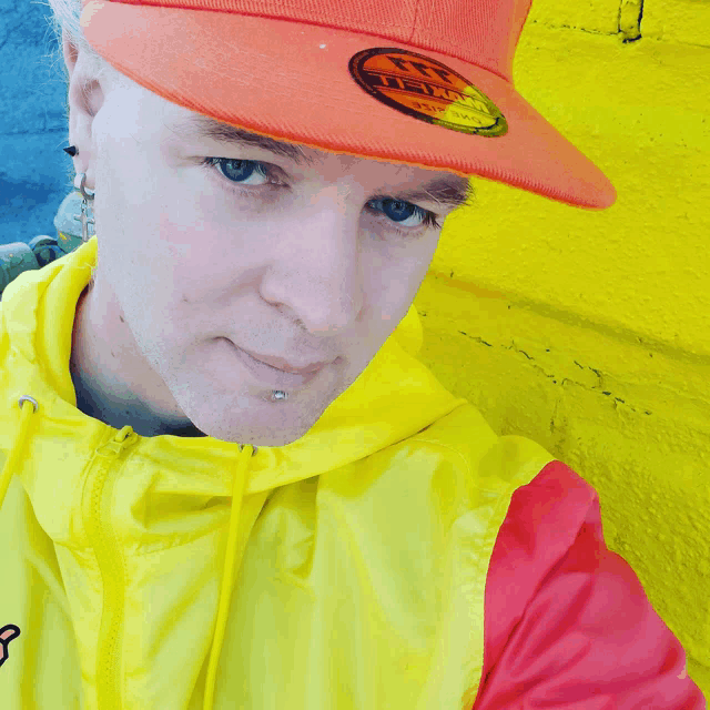a man wearing a yellow and red jacket and an orange hat with the letters u.s.a. on it