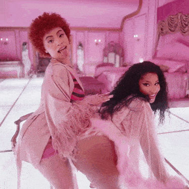 a woman with red hair is sticking her tongue out next to a woman in pink
