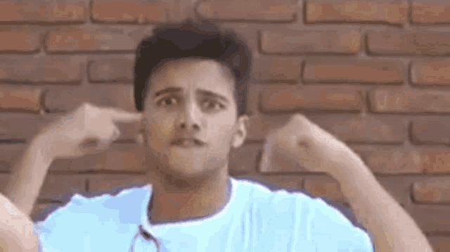 a man with a mustache is covering his ears with his hands .