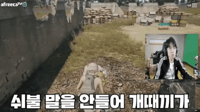 a man is playing a video game on a green screen with korean writing on the screen