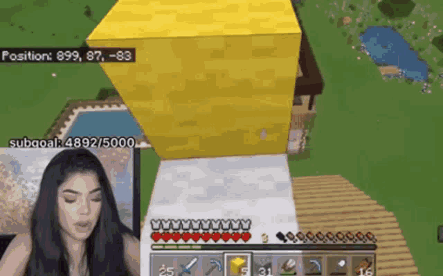 a woman is playing a video game with a yellow cube in the background