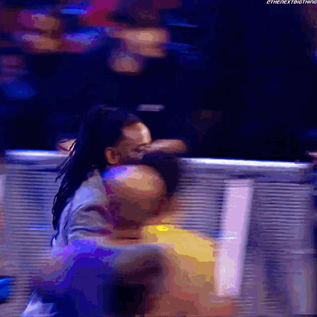 a blurry picture of a man hugging another man with the words " the next thing " written on the bottom