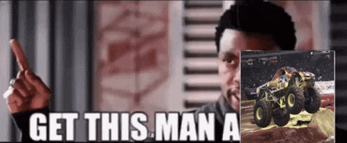 a man is pointing at a monster truck with the words get this man a on the bottom