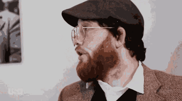 a man with a beard wearing glasses and a hat with the letters usa on the bottom
