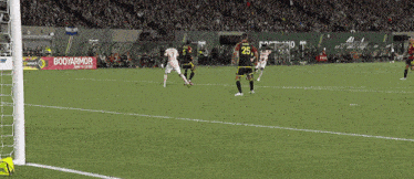 a soccer game is being played in a stadium with a banner that says ' alaska ' on it