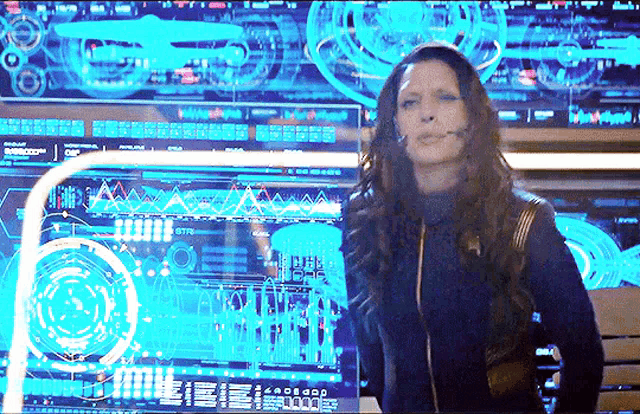 a woman wearing a headset is standing in front of a large screen that says ' eee ' on it