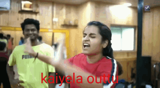 a woman in a red shirt is singing in front of a man in a yellow shirt with the word puma on it