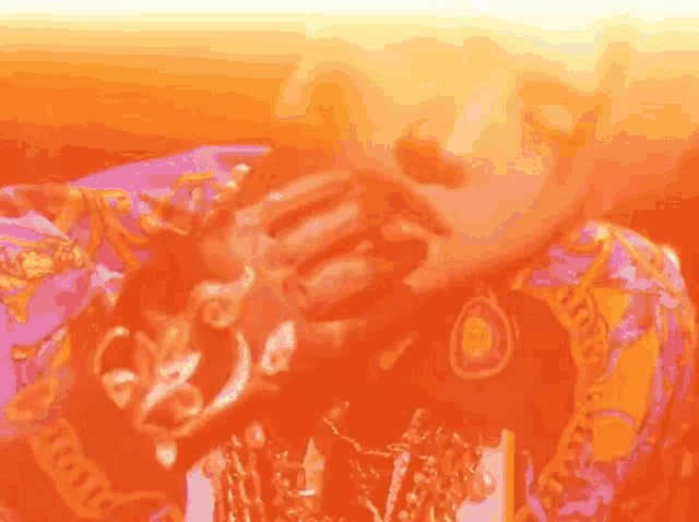 a person wearing a purple and orange shirt with the word versace written on it